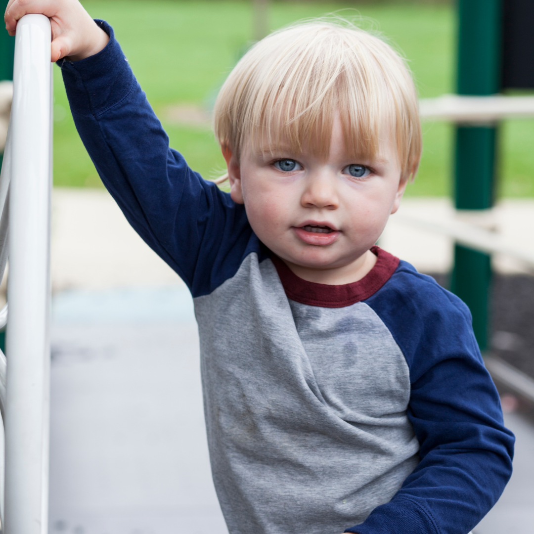 2-year-old child showing early signs of speech delay with concerned parent nearby